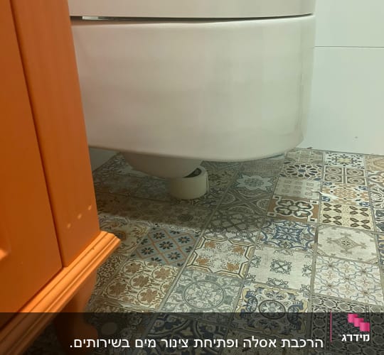 אסלה תלויה עם צינור פלסטיק על הרצפה